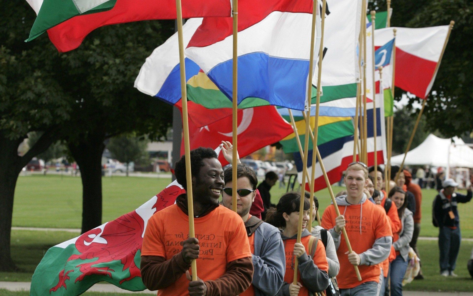 BGSU的学生手持国际旗帜走过校园.