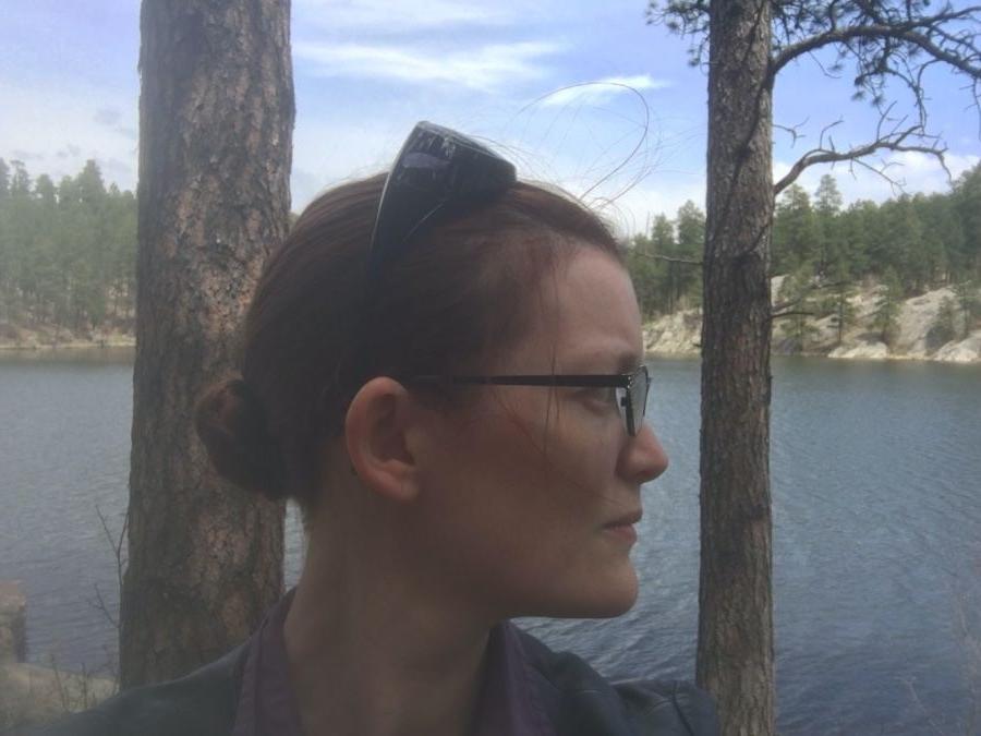 查莉蒂·吉文斯在湖边和绿树成荫的地方望向远处的照片