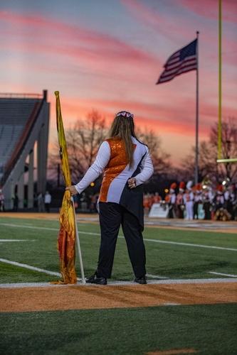 一个学生在日落时分举着国旗